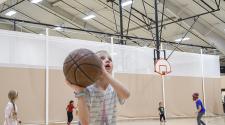 This image shows a girl shooting a basketball at the youth basketball program.