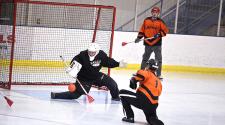 This image shows the goalie stopping a shot during adult broomball.