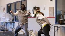This image shows two people in a fencing duel during the adult fencing program.
