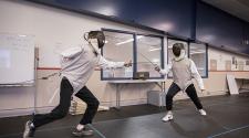 This image shows two children learning how to fence at the youth fencing program.