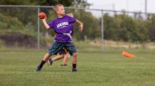 This image shows a boy throwing the football at the youth football program.