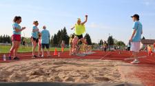 This image shows a girl doing the long jump during the track and field program.