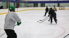 This image shows men skating on the ice at Drop In Hockey.