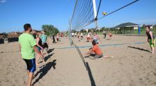 This image shows a sand volleyball match being played. 