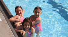 This image shows three girls swimming in a pool.