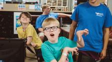 This image shows two boys and an instructor posing for the camera during the youth adaptive summer camp.