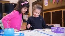 This image shows two girls working on their projects during an art class.