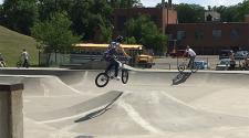 This image shows two people on BMX bikes at the skate park.