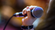This image shows a hand holding up a microphone.