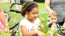 This image shows a girl picking a flower pot at a Hello Spring event.