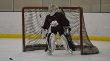 This image shows a goalie getting ready to make a save at youth hockey skills training.