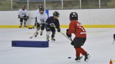 This image shows two kids doing a drill at youth hockey skills training.