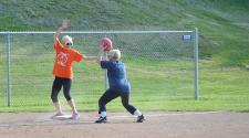 This image shows a female trying to get another player out at a base during kickball league.