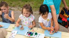 This image shows three girls working on their monsters at a craft table during Monstrous Imagination.