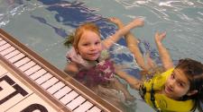 This image shows two girls in the pool at Open Swim.