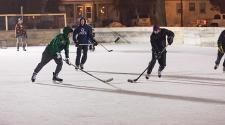 This image shows a game of hockey happening on an outdoor rink.