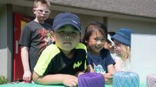 This image shows two kids smiling for the camera during a yarn project at Park It.
