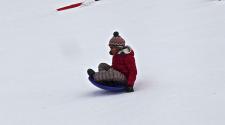 This image shows a girl sledding down the hill.