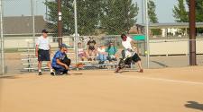 This image shows a batter, catcher and the umpire at adult softball league.