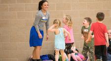 This image shows a group of kids running to the instructor at the sports sampler.