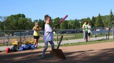 This image shows a girl hitting the ball at the youth tee-ball program.