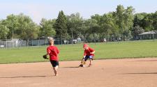 This image shows a boy fielding the ball during the youth tee-ball program.