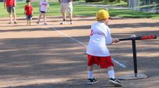 This image shows a boy hitting the ball at the youth tee-ball program.