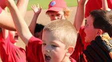 This image shows a team celebrating after a youth tee-ball game.