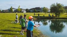 This image shows some kids casting their rods into the pond at Trout Fest.