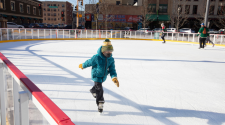This image shows a young boy skating on the rink at Broadway Square.