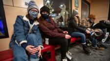 This image shows four people putting on skates inside the Skate Shack at Broadway Square.