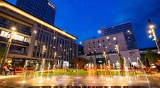 This image shows Broadway Square with the spouts on at night. 