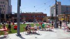 This image shows people enjoying Broadway Square during a sunny, summer day.