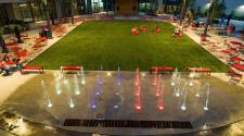 This image shows an aerial view of the Square Spouts lit up at night.