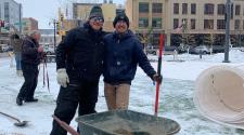 two men with shovel and wheelbarrow.