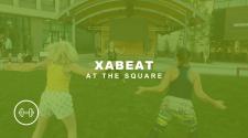 photo shows people doing xabeat at the square with a weight icon