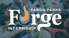 Forge Logo (Fargo Parks Forge Internship with a flame for the O in Forge) in white with a faded image of a group of young staff with their hands in about to break from a huddle over a desk