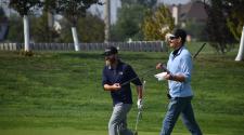 two men walking on a golf course