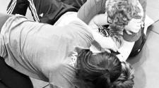 Participants practice hands-on self-defense techniques during a training session.